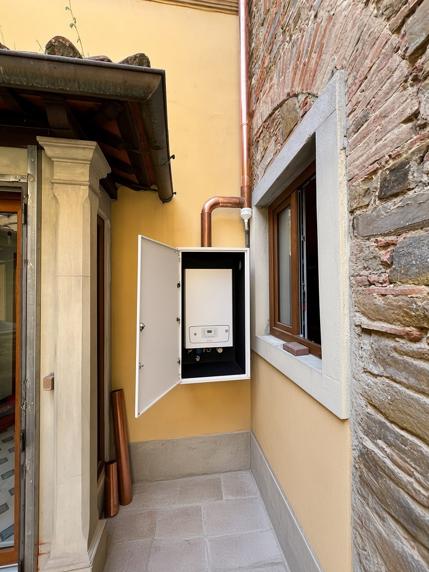 Installazione caldaia a muro con tubazioni in rame su facciata
